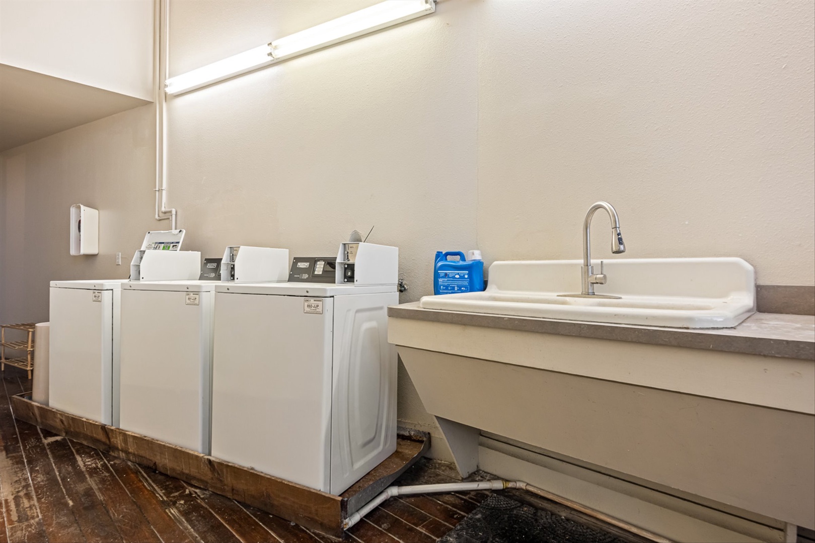 Laundry space is next door with three machines and a sink.