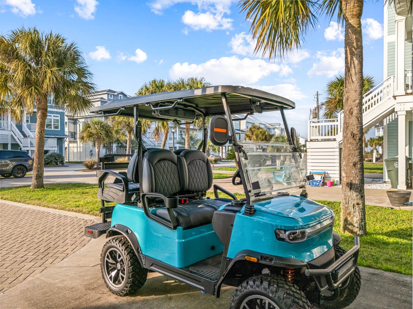 Cruise through a tropical coastal neighborhood by golf cart.