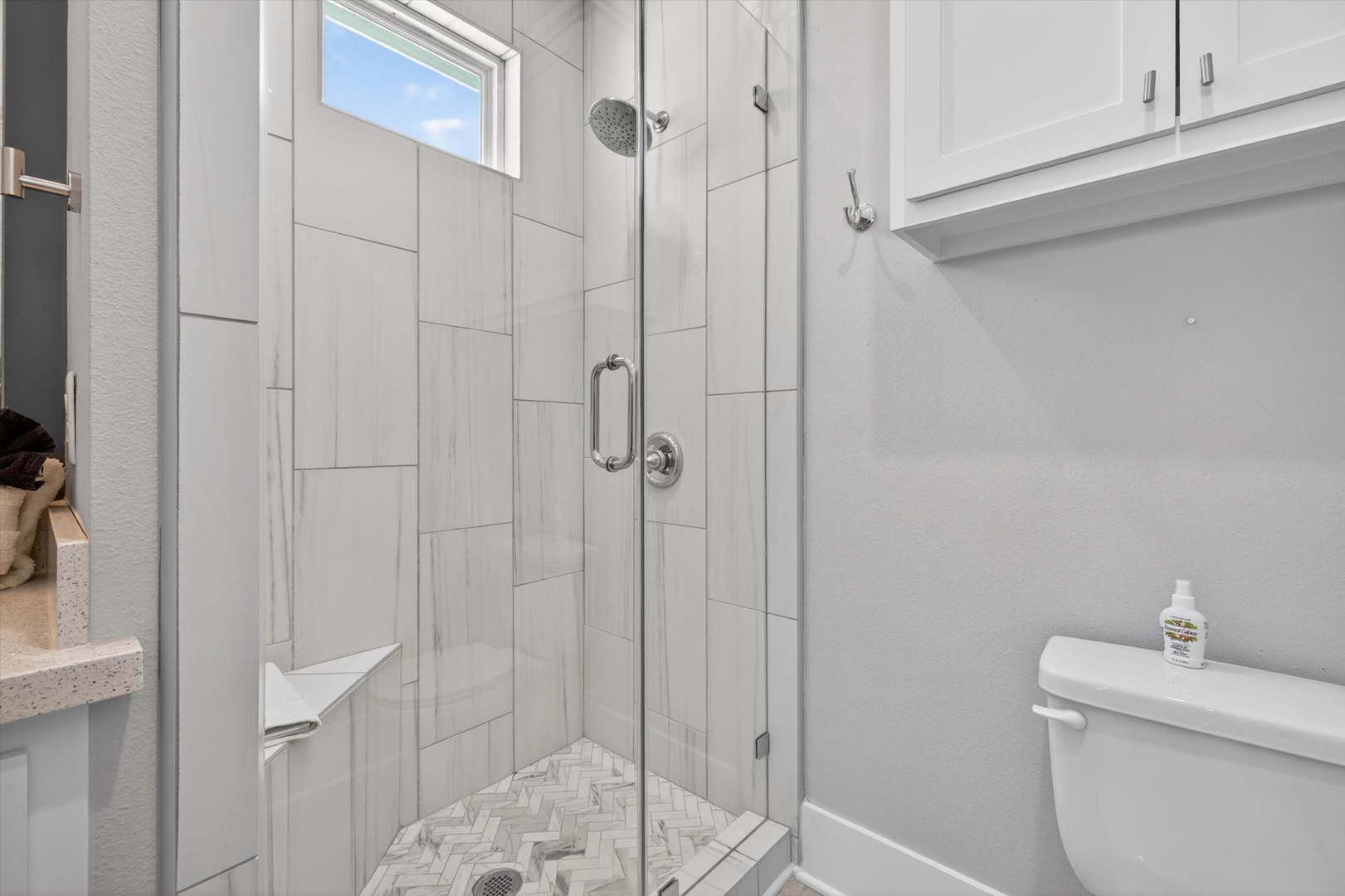 Glass shower bathroom with elegant herringbone tile.