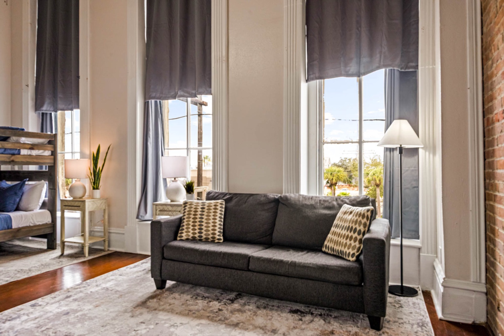 Unwind on a plush sofa with natural light and urban views.