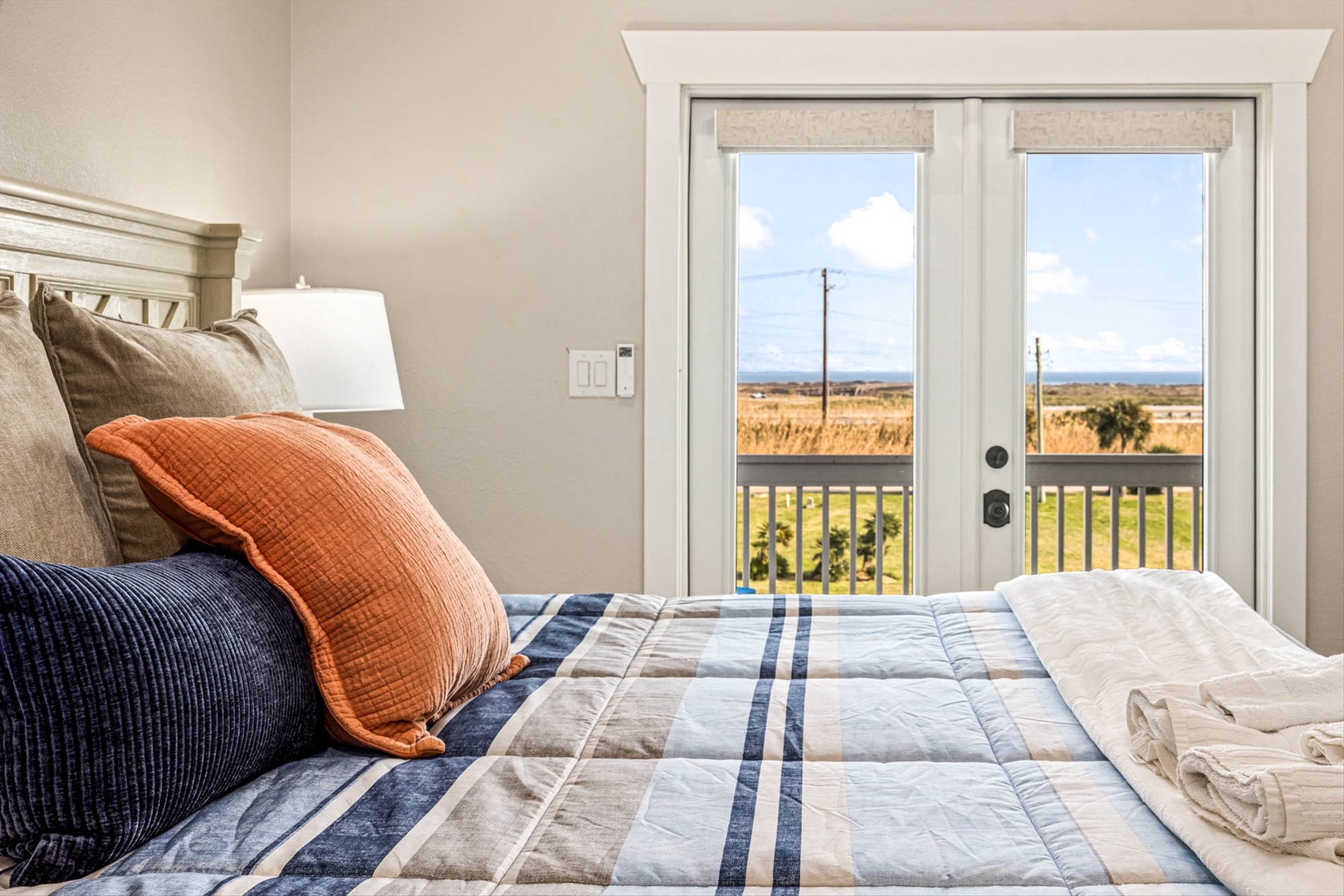 Primary bedroom with French doors and scenic countryside.