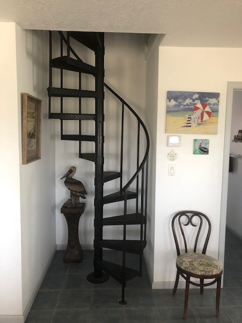 Climb your charming spiral staircase to discover cozy upper levels, surrounded by coastal artwork that sets a peaceful seaside mood throughout your stay.