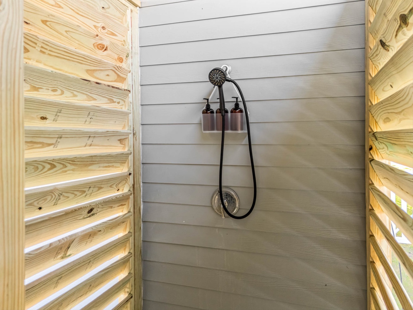 Private outdoor shower with premium fixtures and warm light.