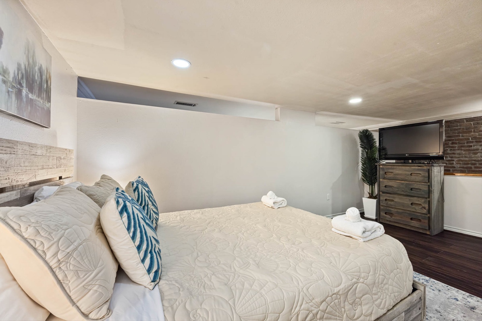 Stylish basement suite with queen bed, TV, and amenities.