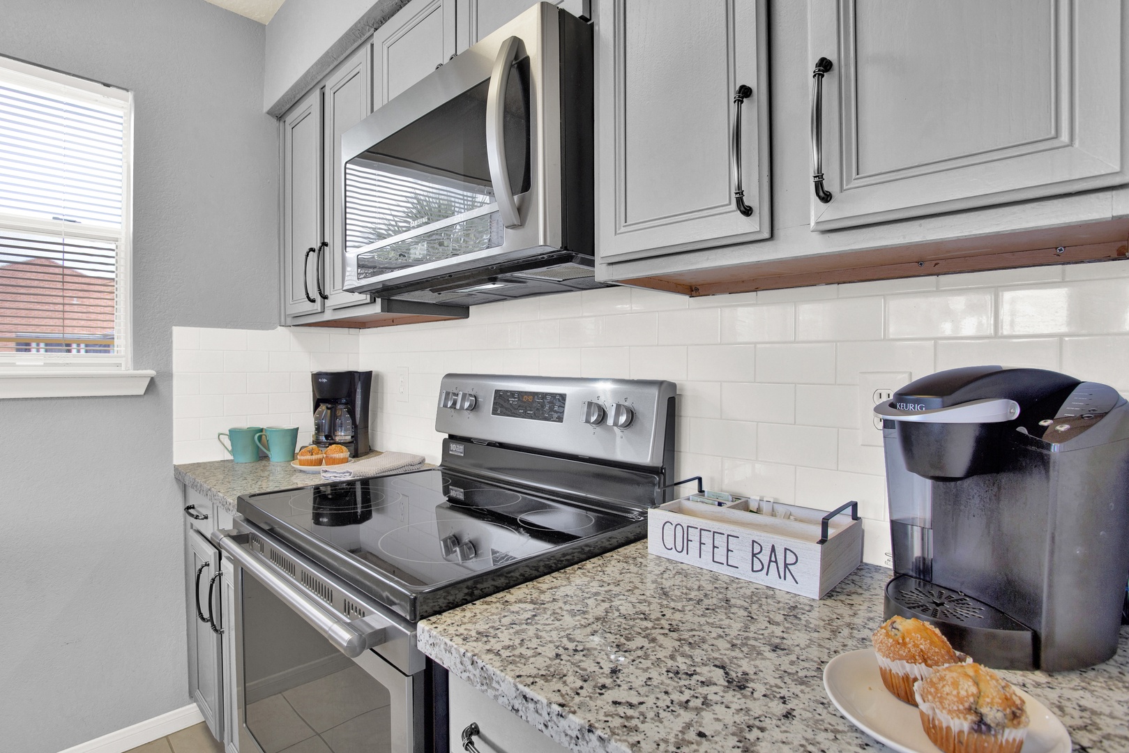 Start your mornings right in this bright, well-appointed kitchen. Granite counters, modern appliances, and a charming coffee bar setup make brewing your favorite cup a pleasure—muffins optional, but highly recommended.
