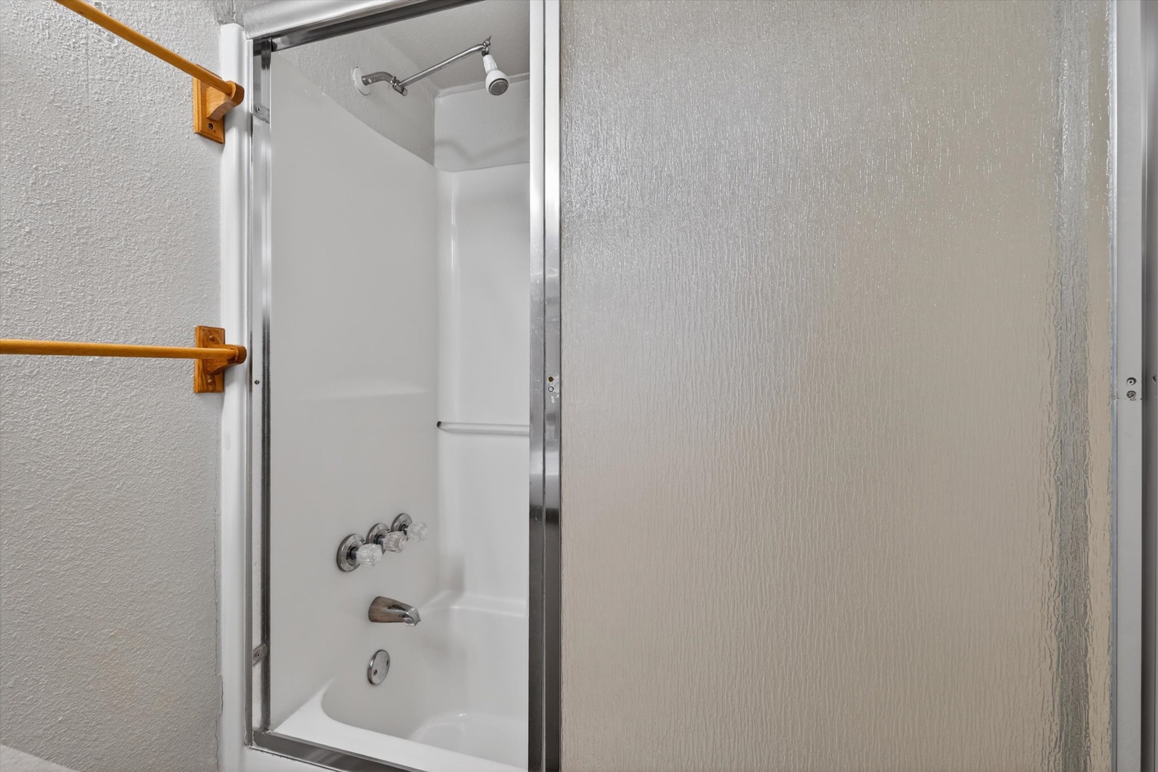 Modern bath with tub-shower combo and glass doors.