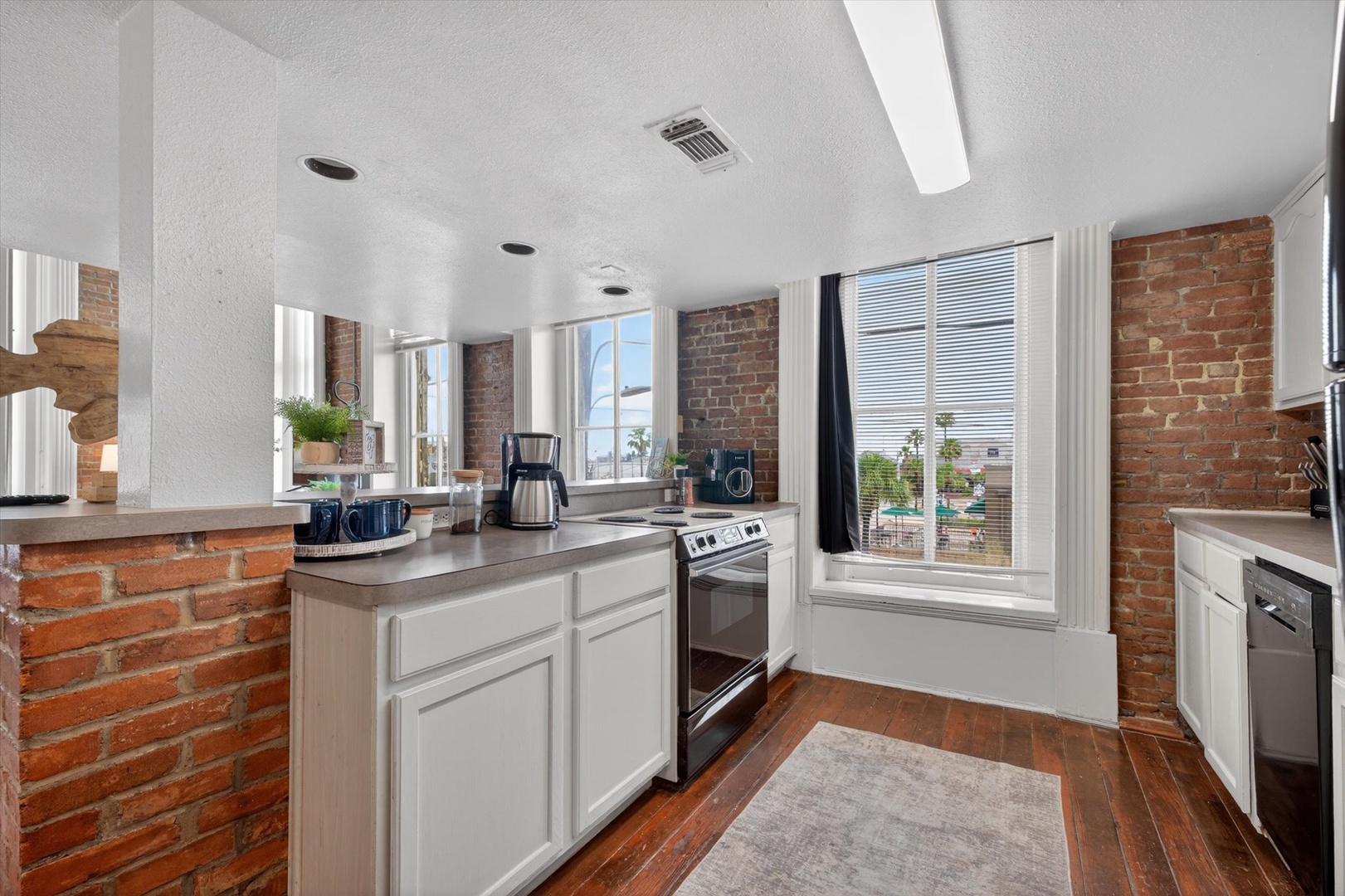 Brick kitchen with sleek appliances and views of the harbor.