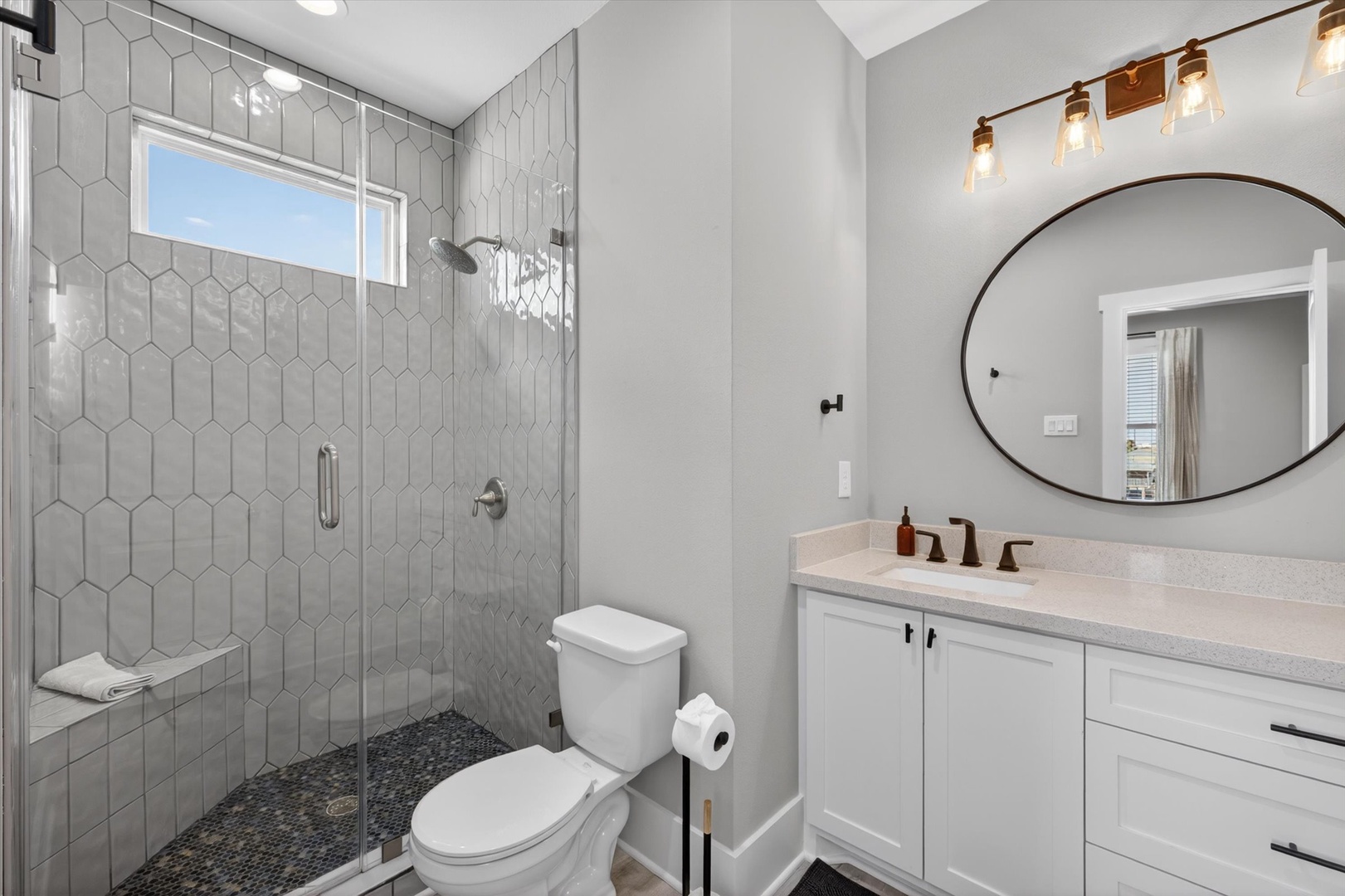 Hex tile shower and warm lighting create a spa retreat.