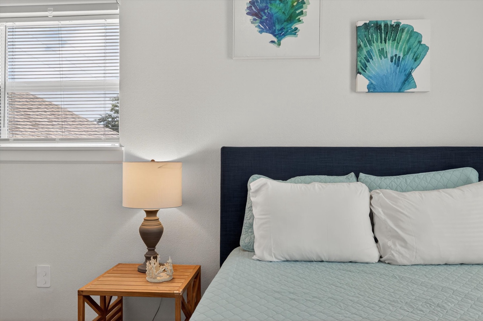 Serene seaside bedroom with soft linens and calm décor.