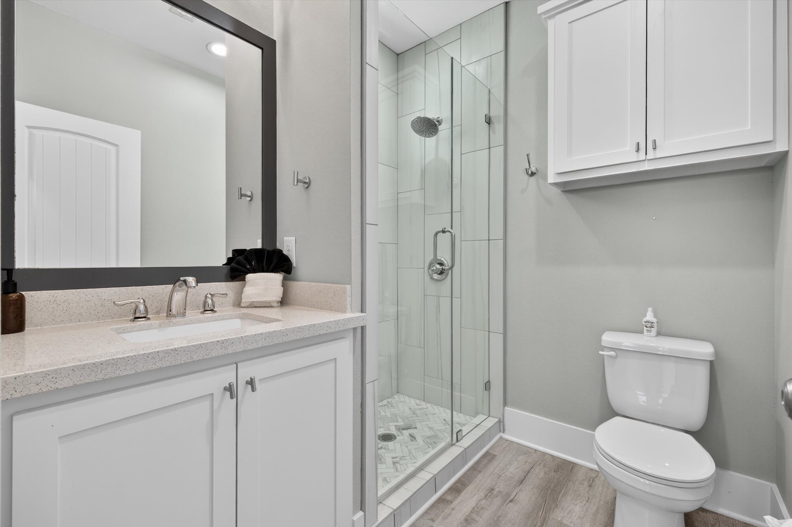 Bright bathroom with glass shower and modern vanity.