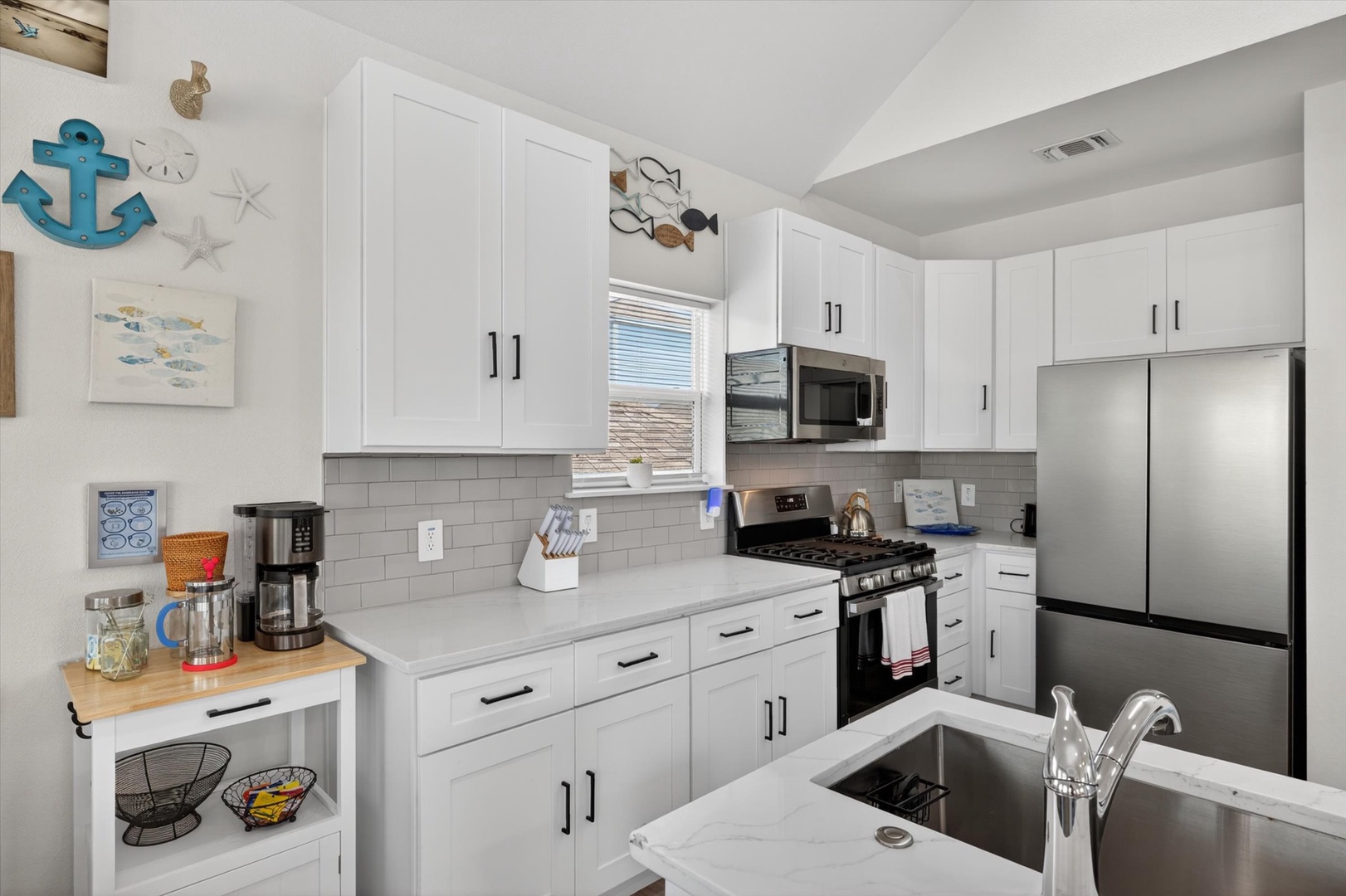 Modern kitchen with white cabinetry and coastal charm.