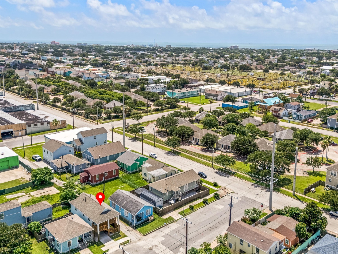 Residential neighborhood aerial with homes and green lawns.