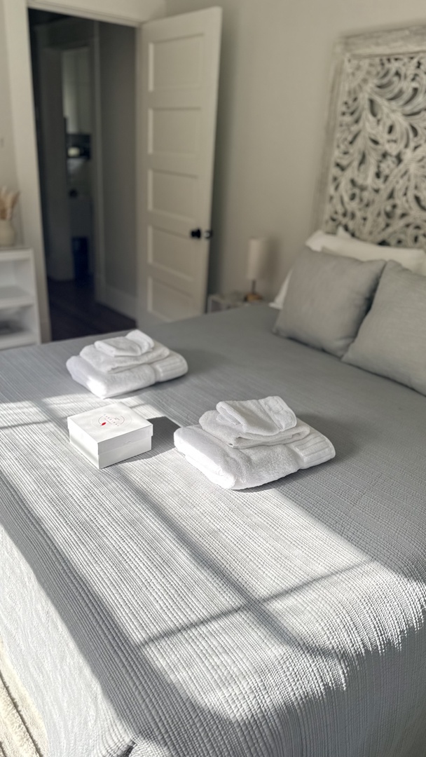 Sink into plush bedding with thoughtfully arranged towels and artisan touches, all bathed in soft natural light filtering through your serene retreat.