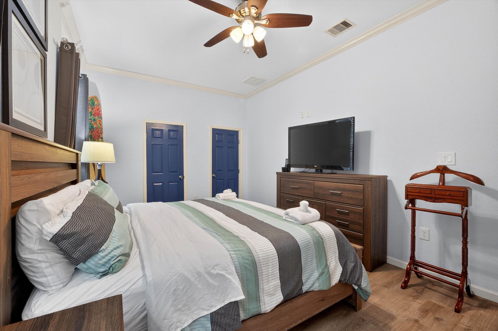 Rest easy in your peaceful primary bedroom featuring a comfortable bed, ceiling fan, and flat-screen TV for unwinding after busy days.