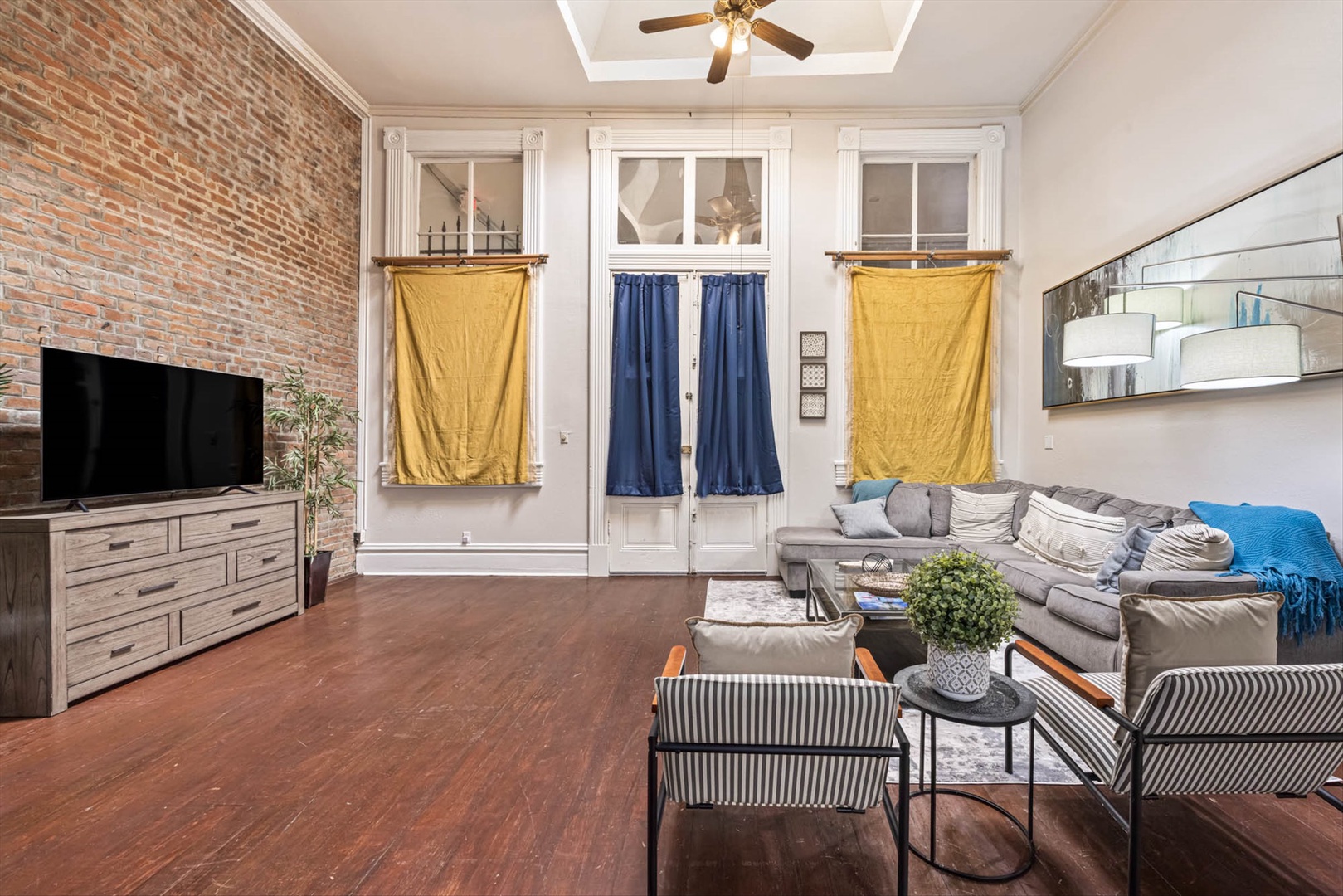 Cozy sectional in living room with exposed brick and high ceilings.