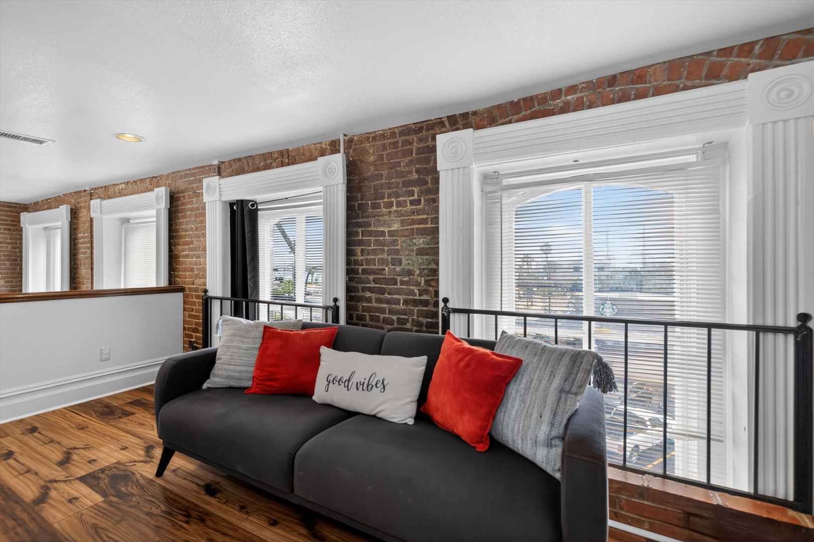 Bright loft with cozy sofa, exposed brick, and views.
