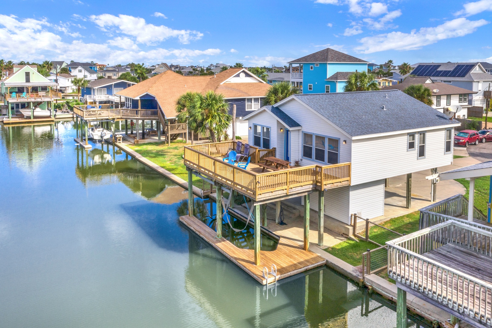 This waterfront vacation home features a private boat dock and spacious deck overlooking the canal, situated in a peaceful coastal neighborhood with nearby beach access and local charm.