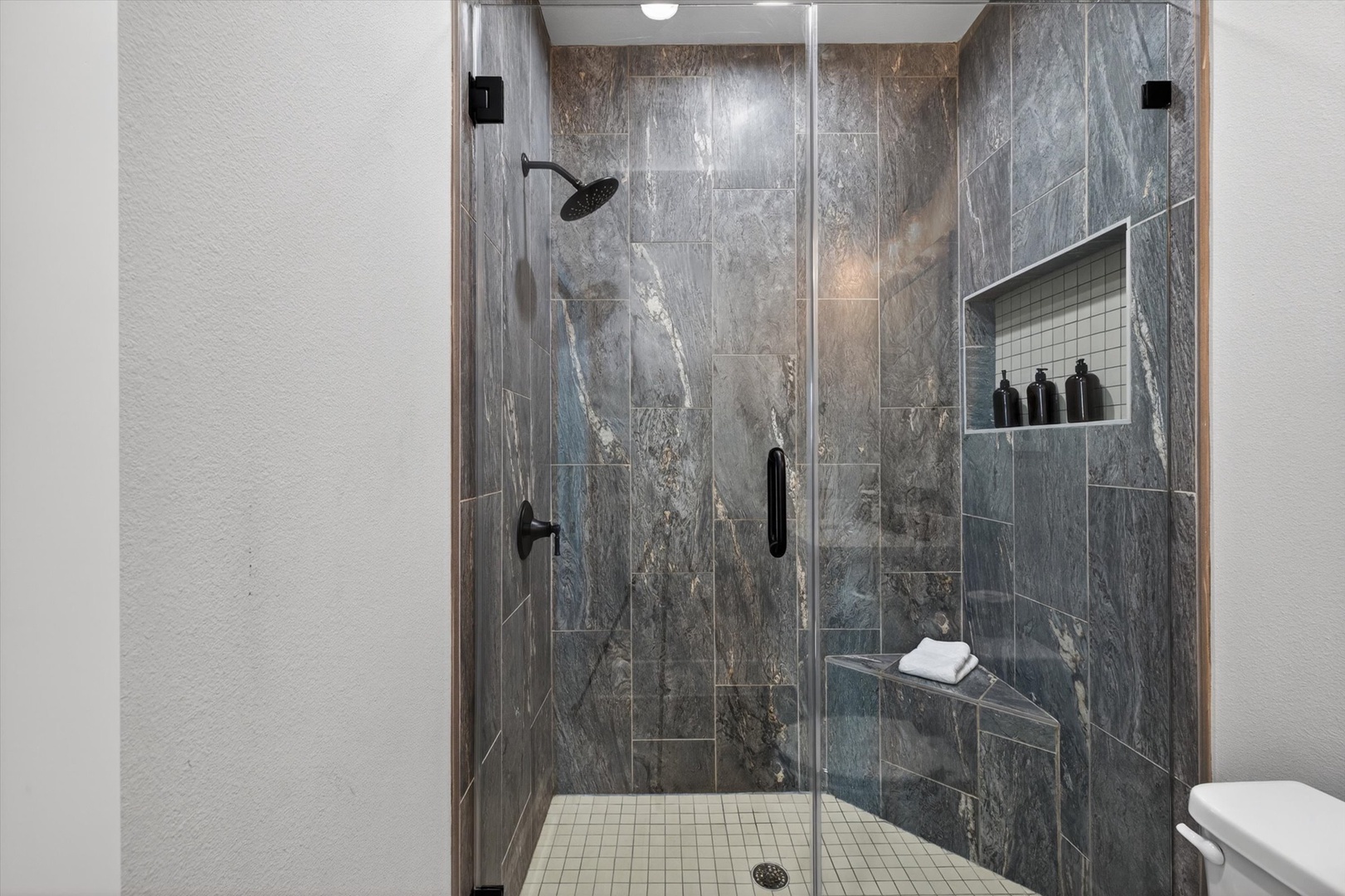Spa-like shower with marble tile and rainfall head.