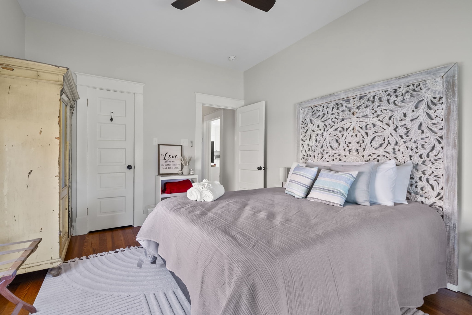 Cozy bedroom with carved headboard and vintage wardrobe.