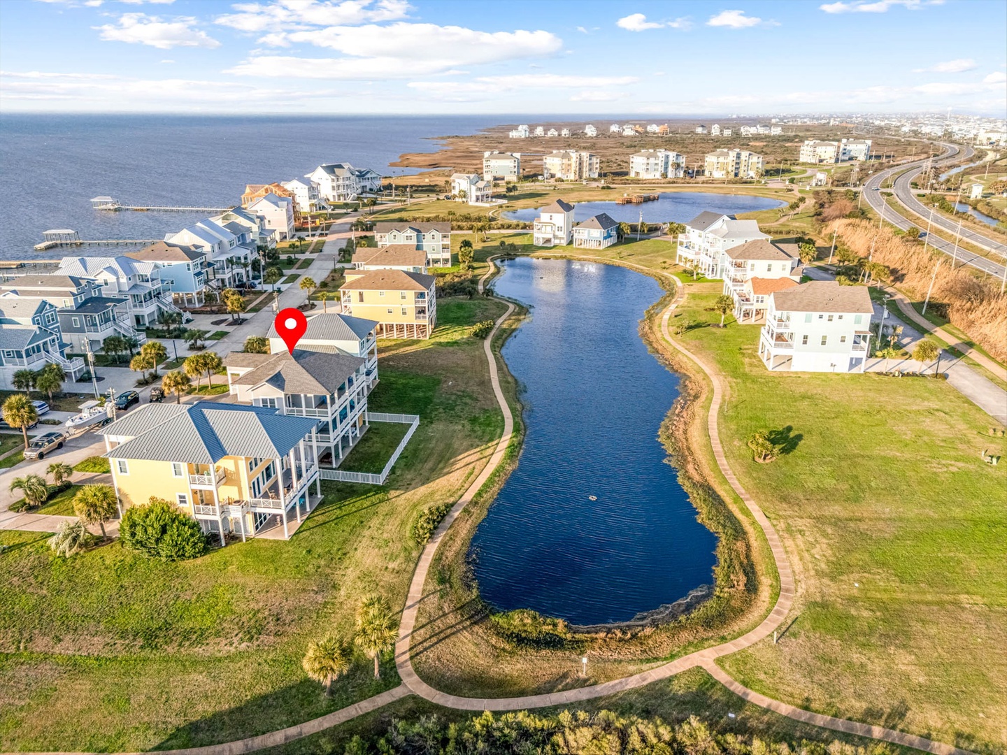 Aerial view of coastal homes with lake and beach access.