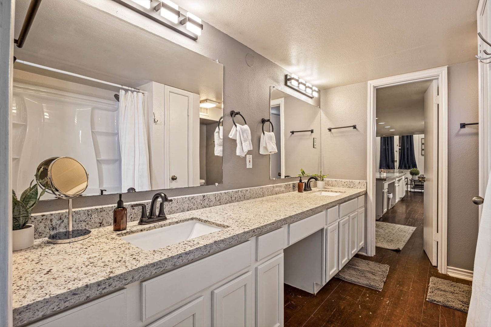 Bathroom with granite countertops, dual sinks, and elegant fixtures.