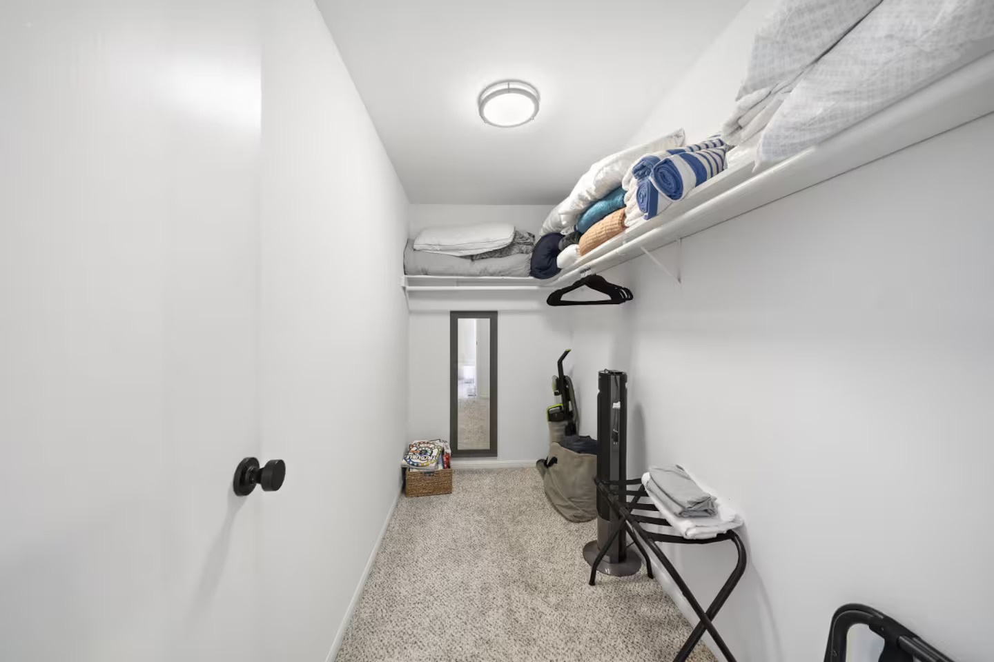 Walk-in closet with storage for towels & luggage