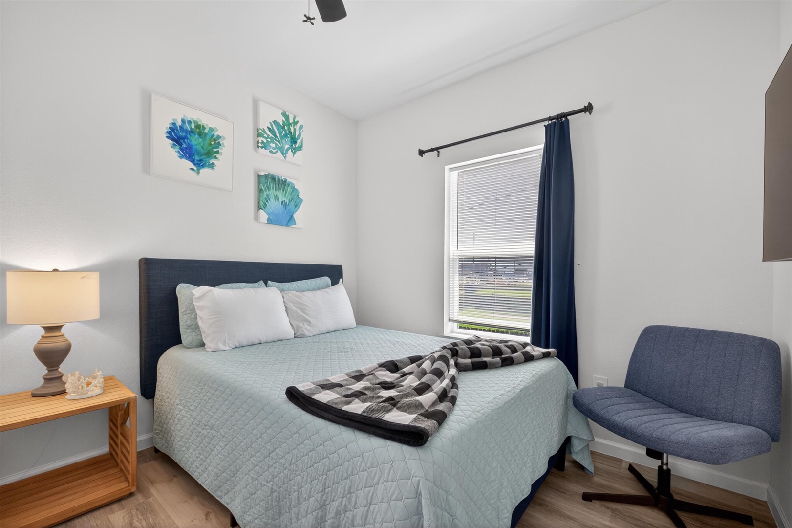 Coastal bedroom with plush bed and serene lighting.