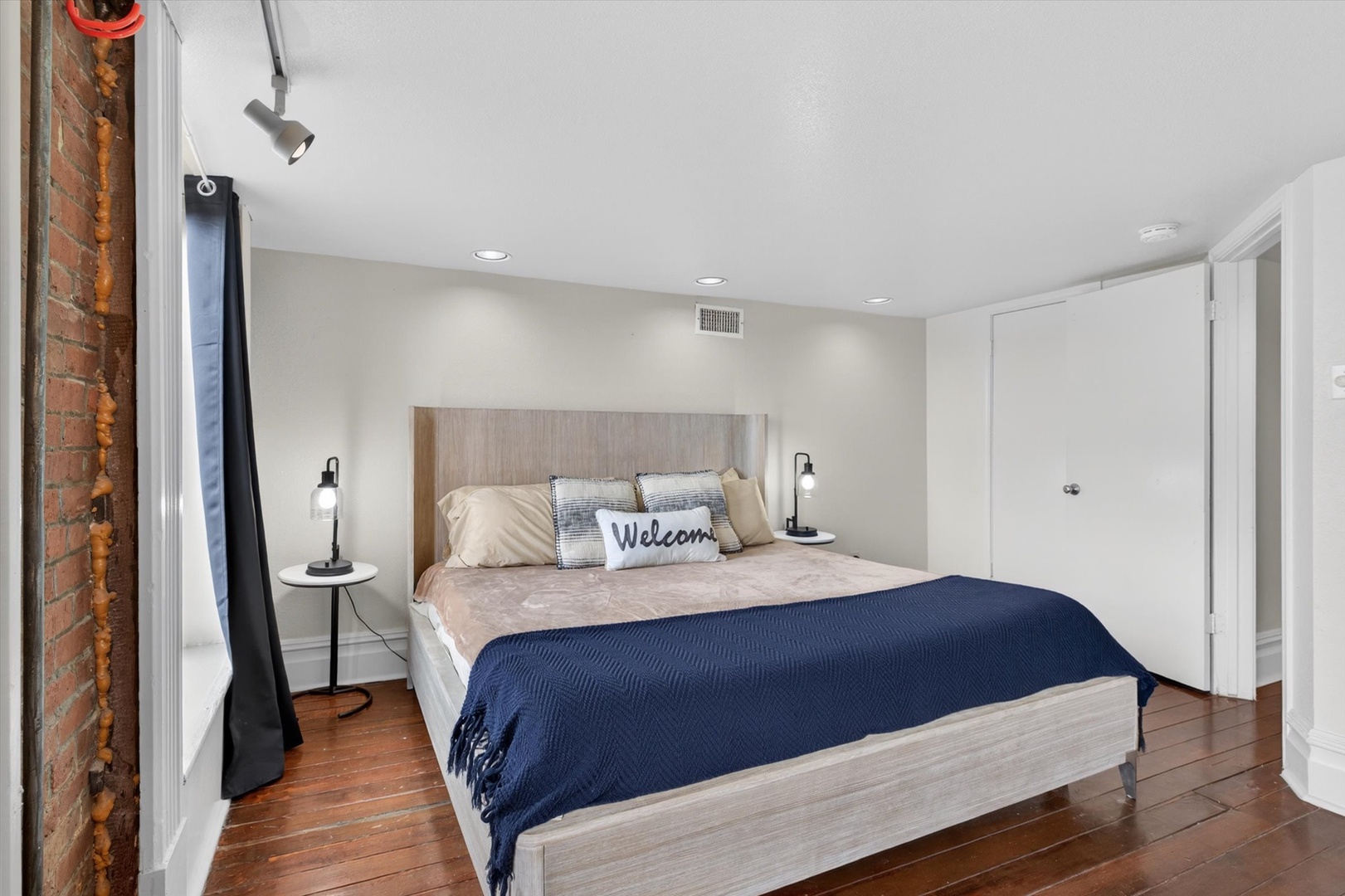 Bedroom with warm glow, brick walls, and wood floors.
