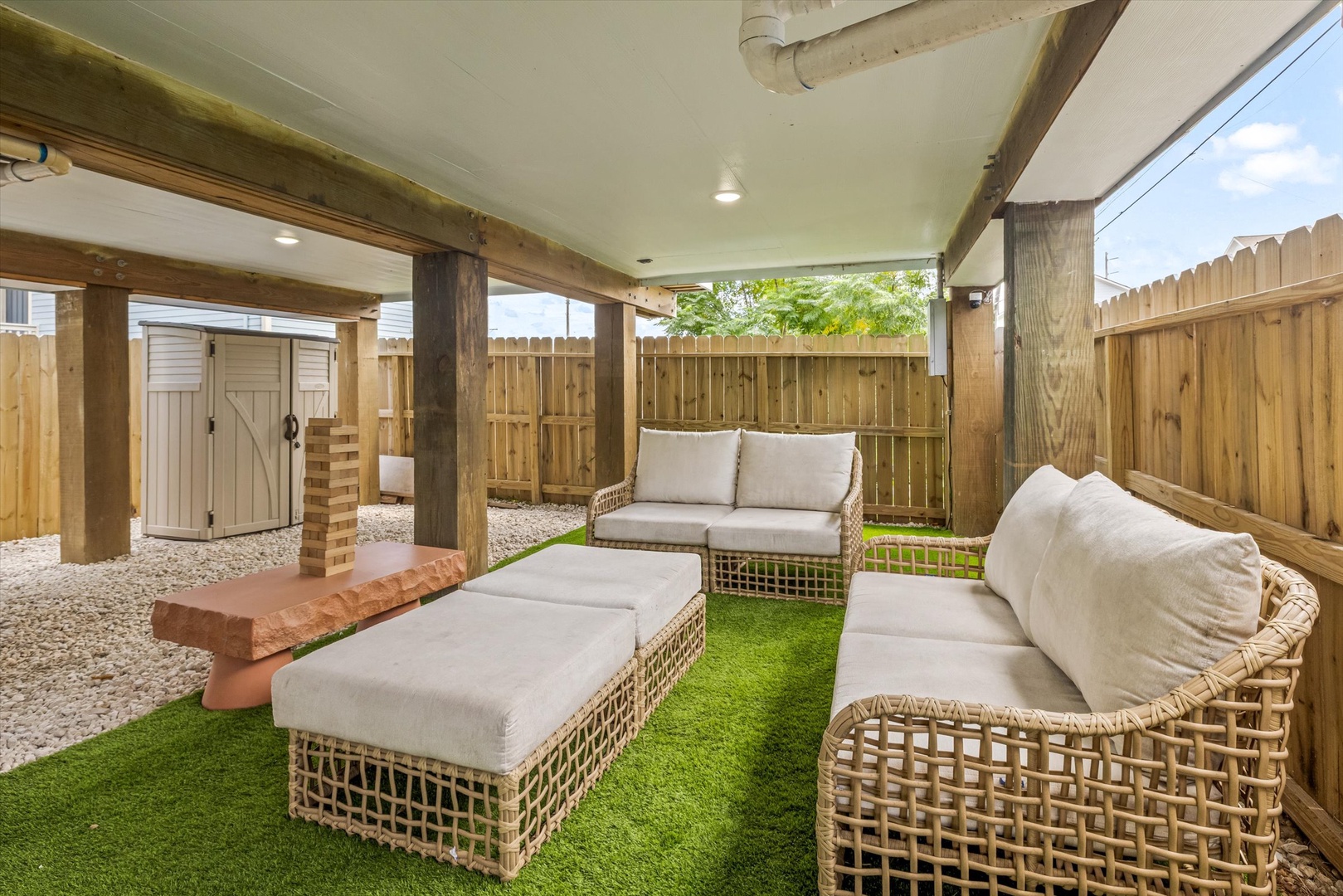 Private patio with outdoor seating and artificial turf.