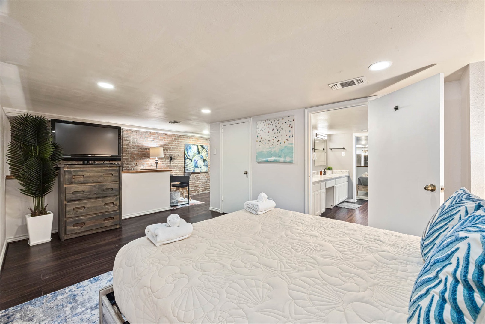 Bedroom with fireplace, flatscreen, and stylish coastal décor.
