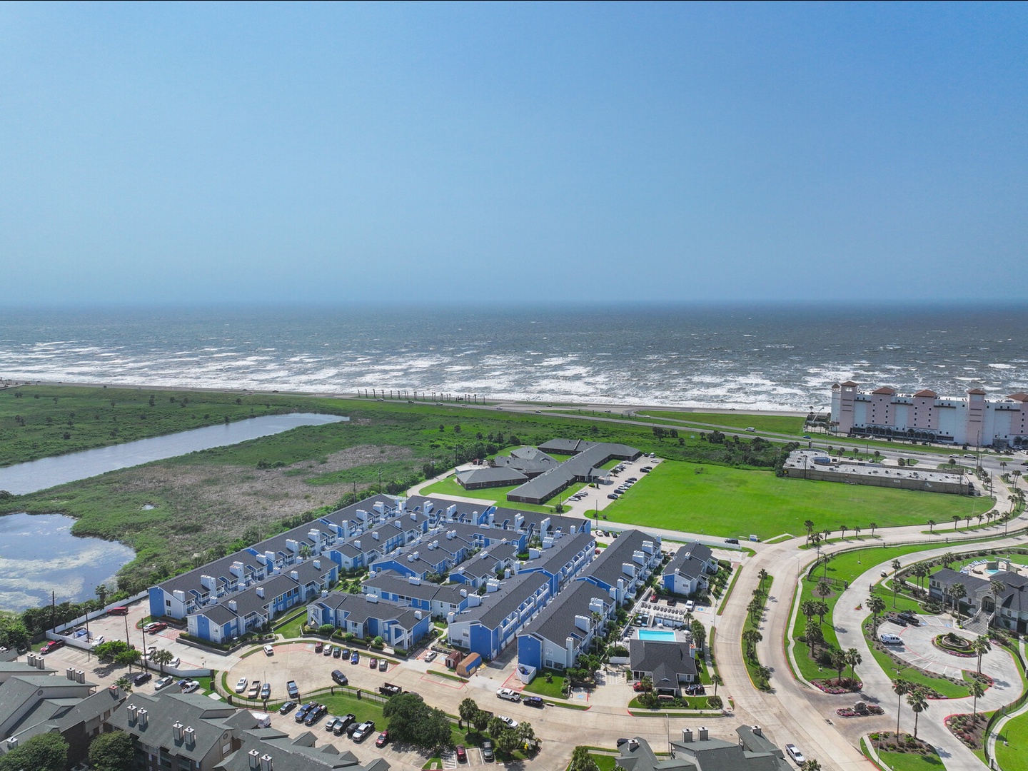 Aerial coastal view with beach access & greenery