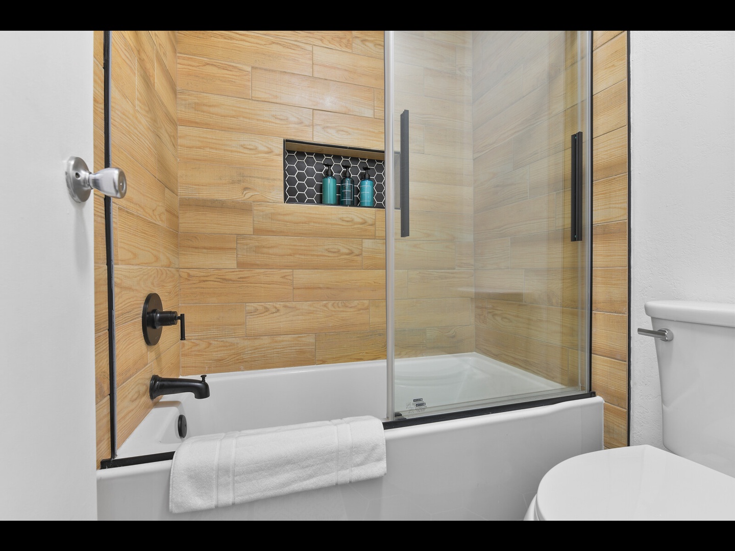 Warm wood bathroom with spacious tub-shower