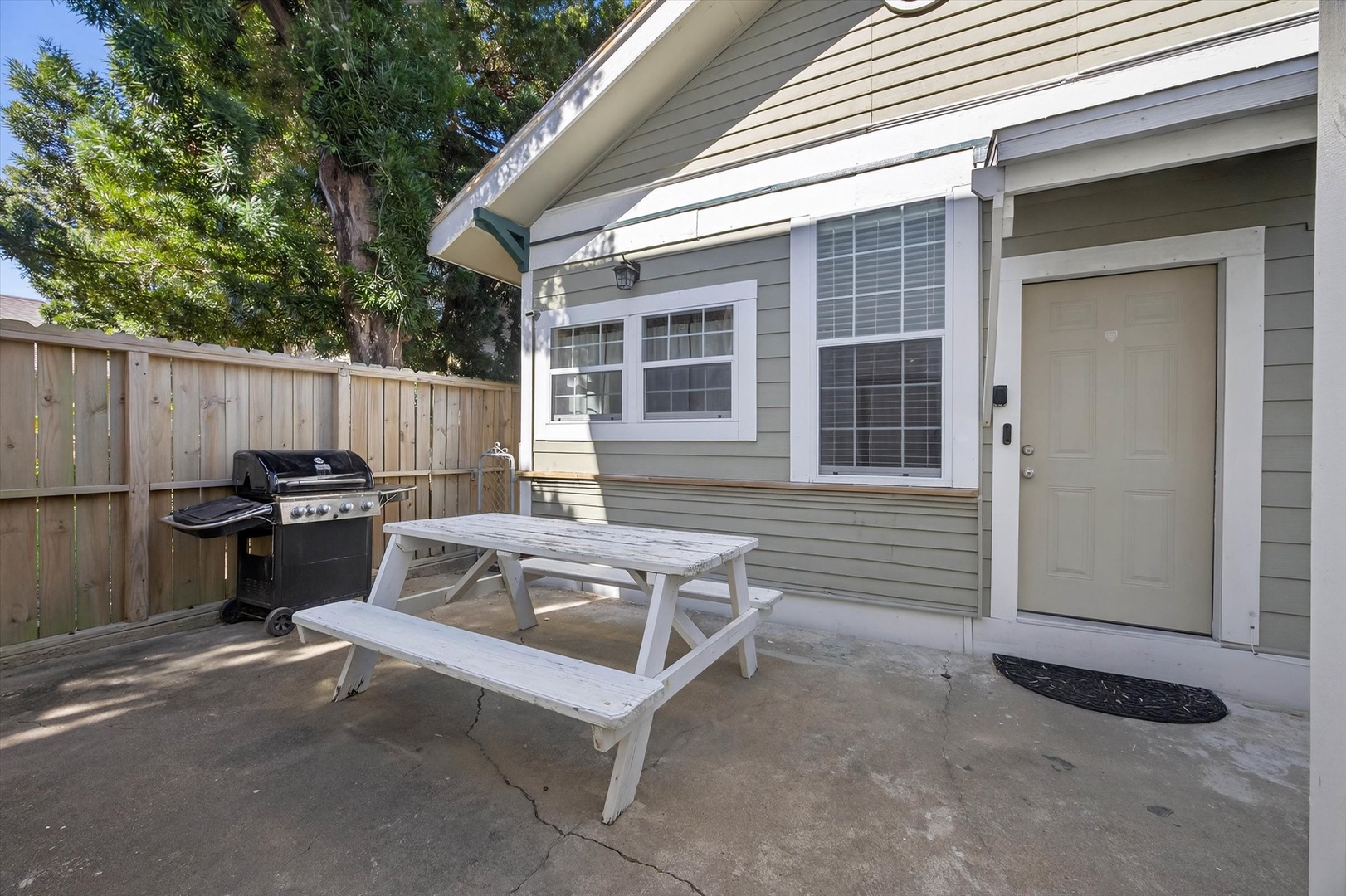Your private patio features a picnic table and gas grill, perfect for outdoor dining surrounded by mature trees and complete privacy.