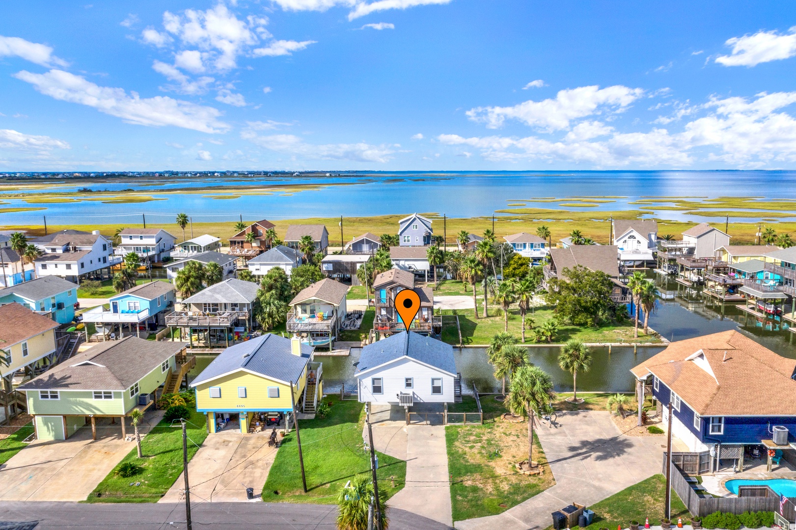A waterfront community where calm bay waters meet coastal marshland, with the property situated along a peaceful canal just moments from the shoreline.