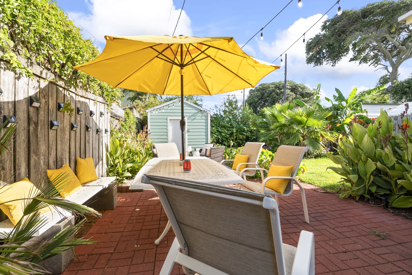 Lounge chairs and umbrellas in a lush tropical garden oasis.