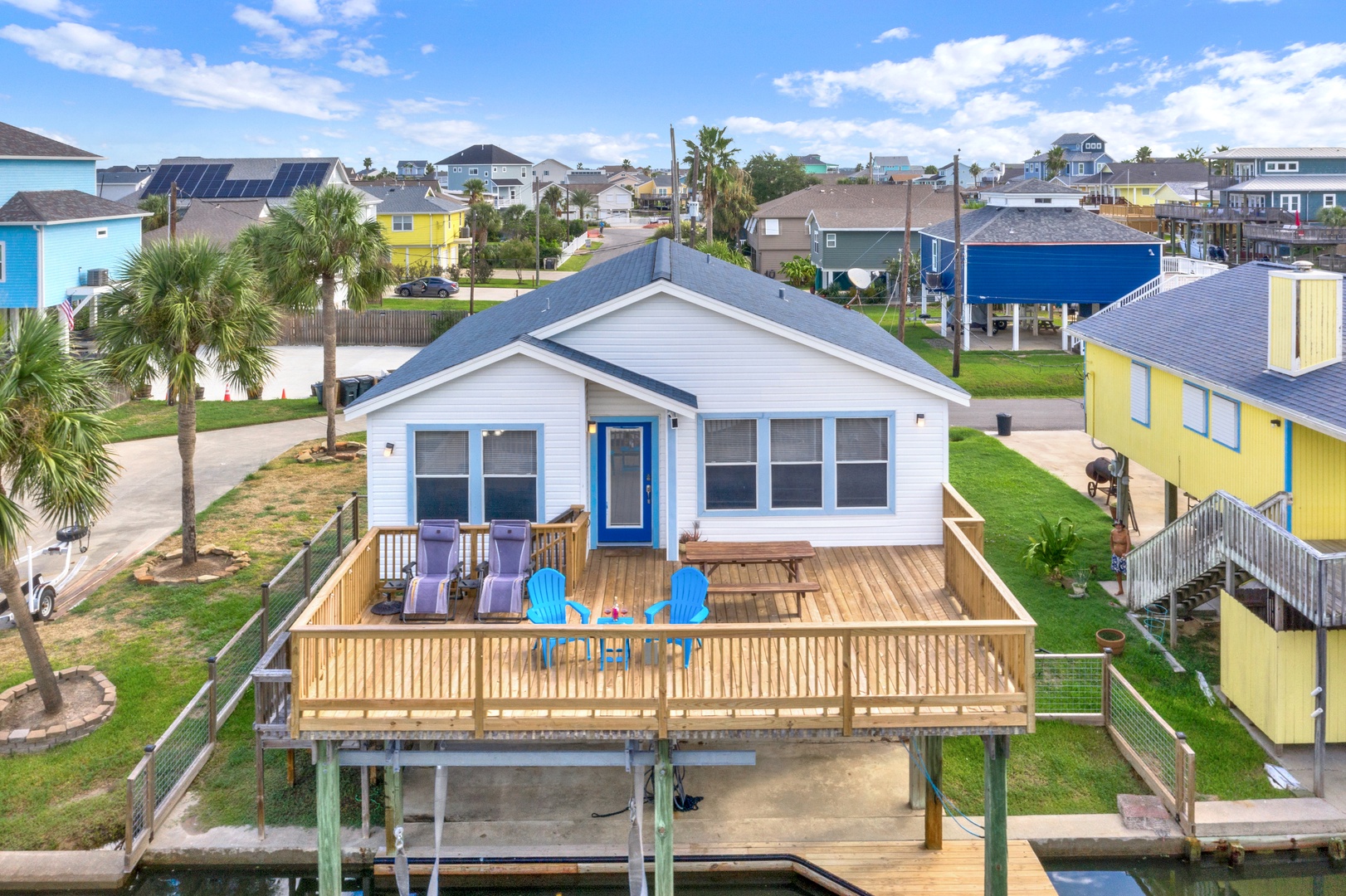Aerial view of your rental, featuring palm trees and waterfront access in a relaxed neighborhood setting.