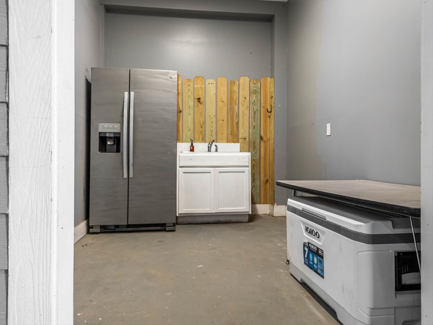 Kitchen with fridge, cooler, and fishing clean up area under house