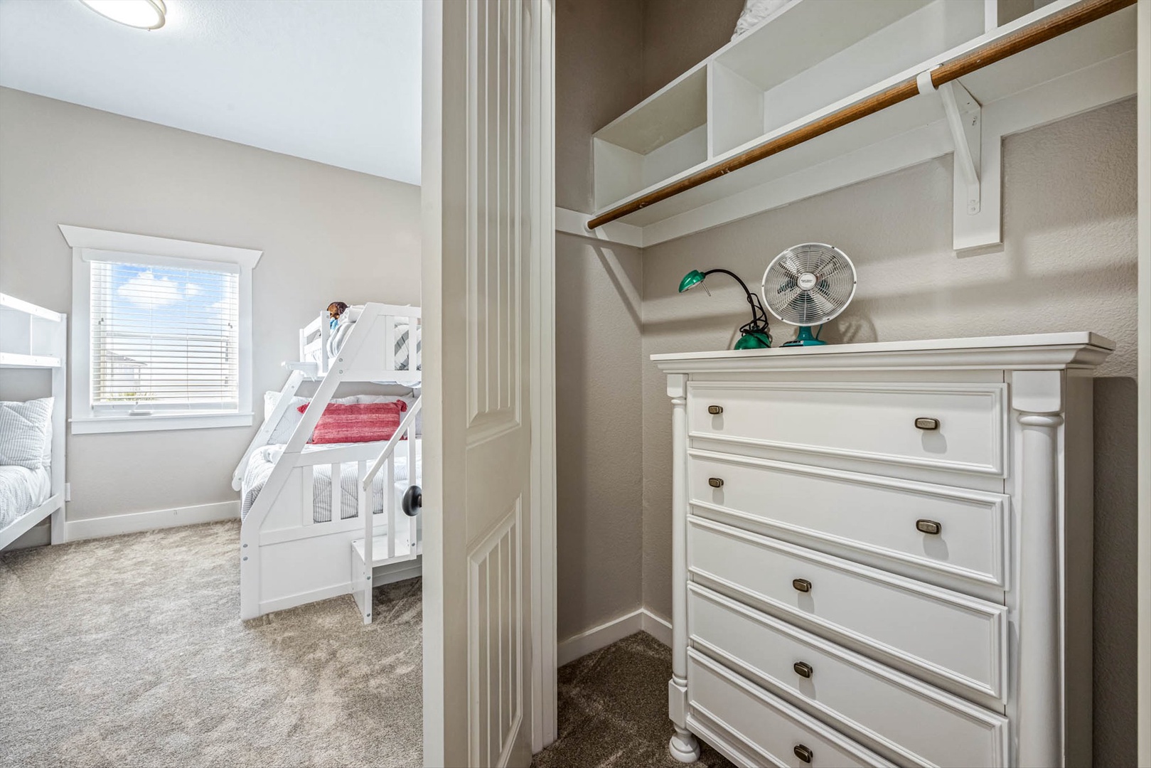Bunk bedroom with built-in closet and dresser.