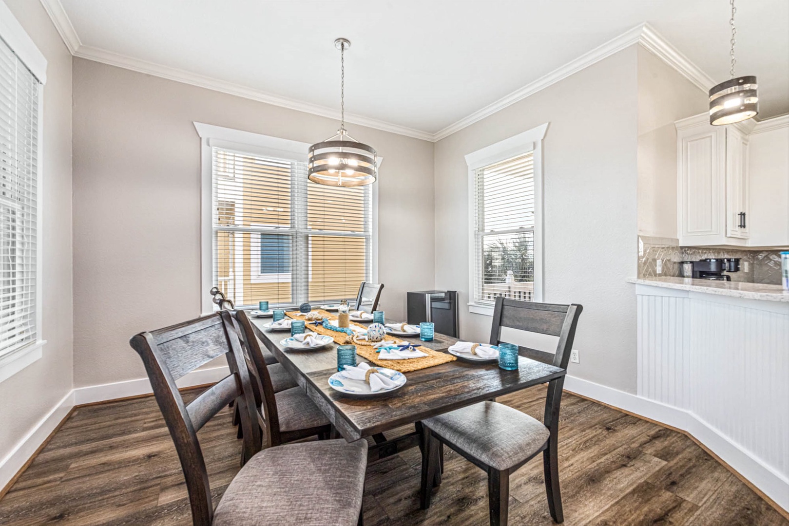 Elegant dining table with warm lighting and kitchen nearby.