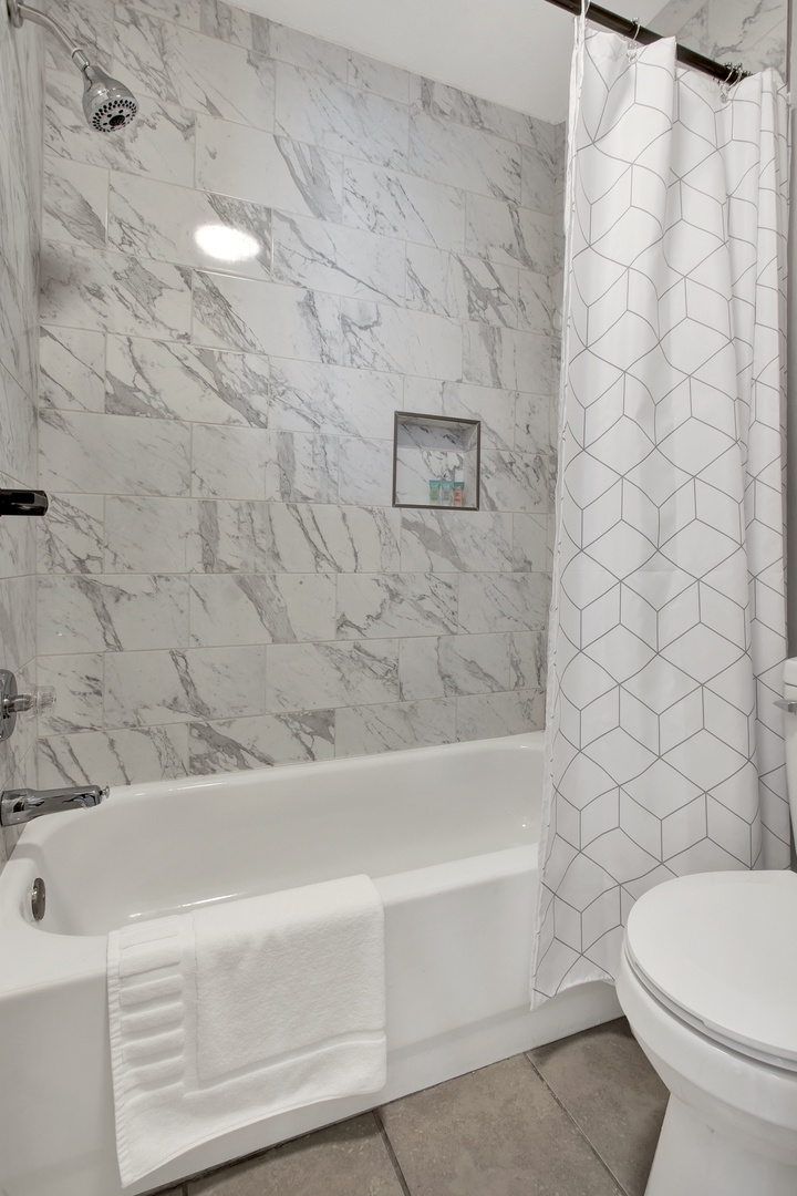 Refresh in your elegant marble-tiled bathroom, where a deep soaking tub awaits your relaxation after a day of exploring.