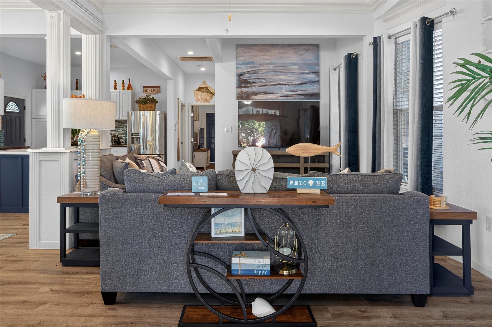 Sink into plush gray sofas in your stylish living room, where coastal artwork and nautical touches create a serene retreat perfect for unwinding.