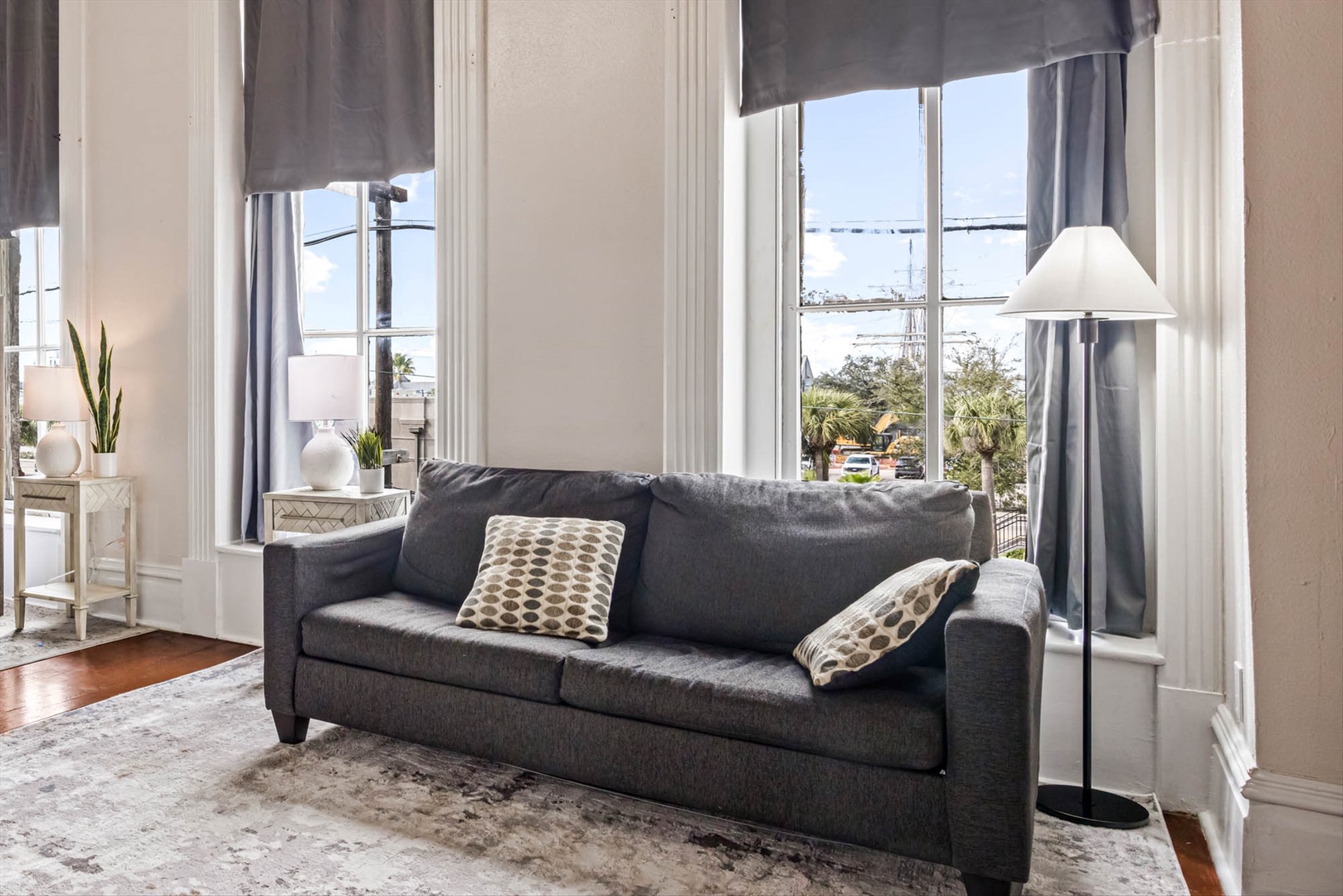 Charcoal sofa in a bright space with elegant sunlit windows.