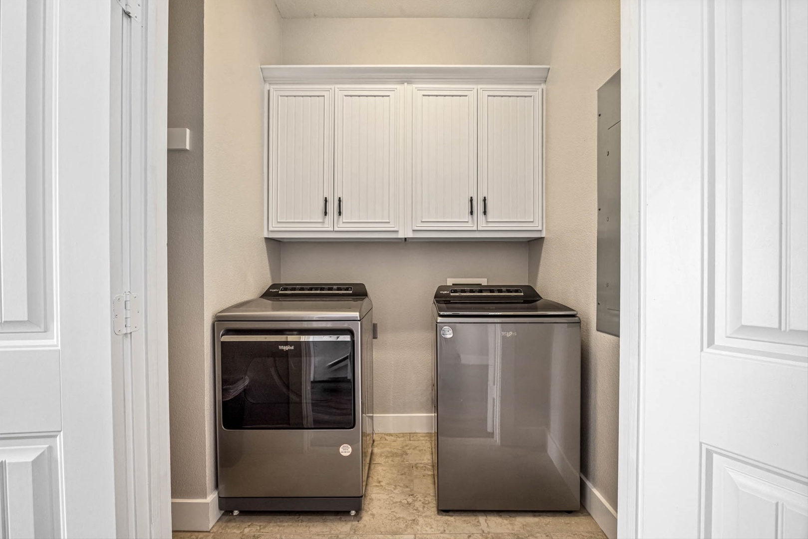 Dedicated laundry with stainless steel machines and storage.