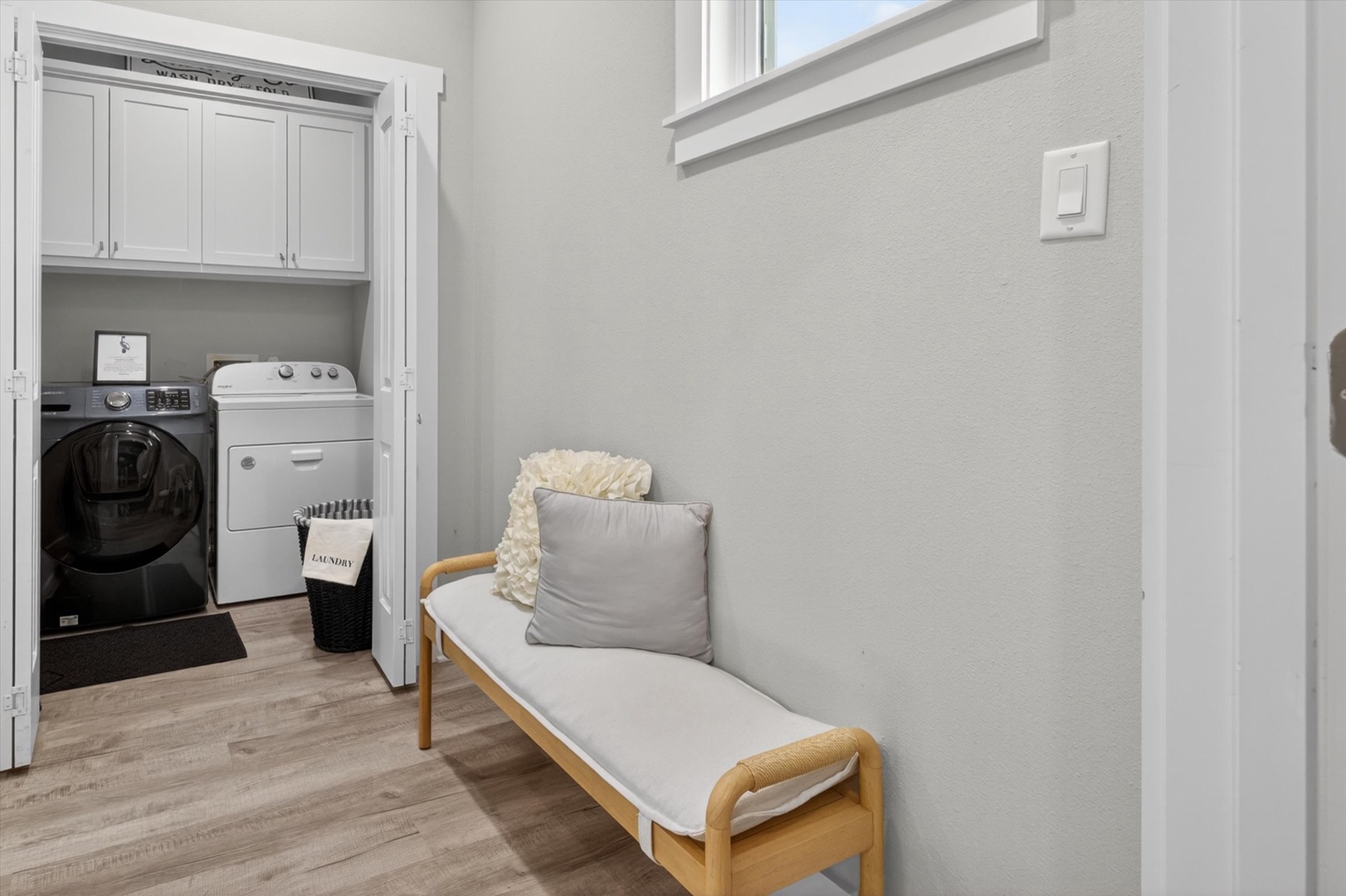 Laundry room with washer, dryer, and folding bench.