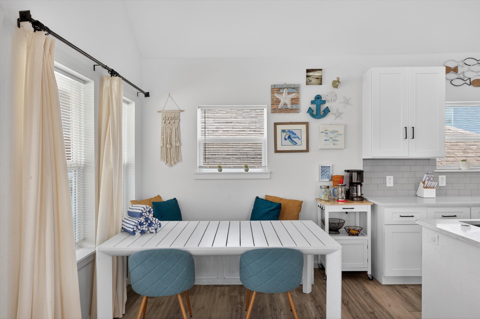 Teal-accent dining nook with open kitchen and charm.