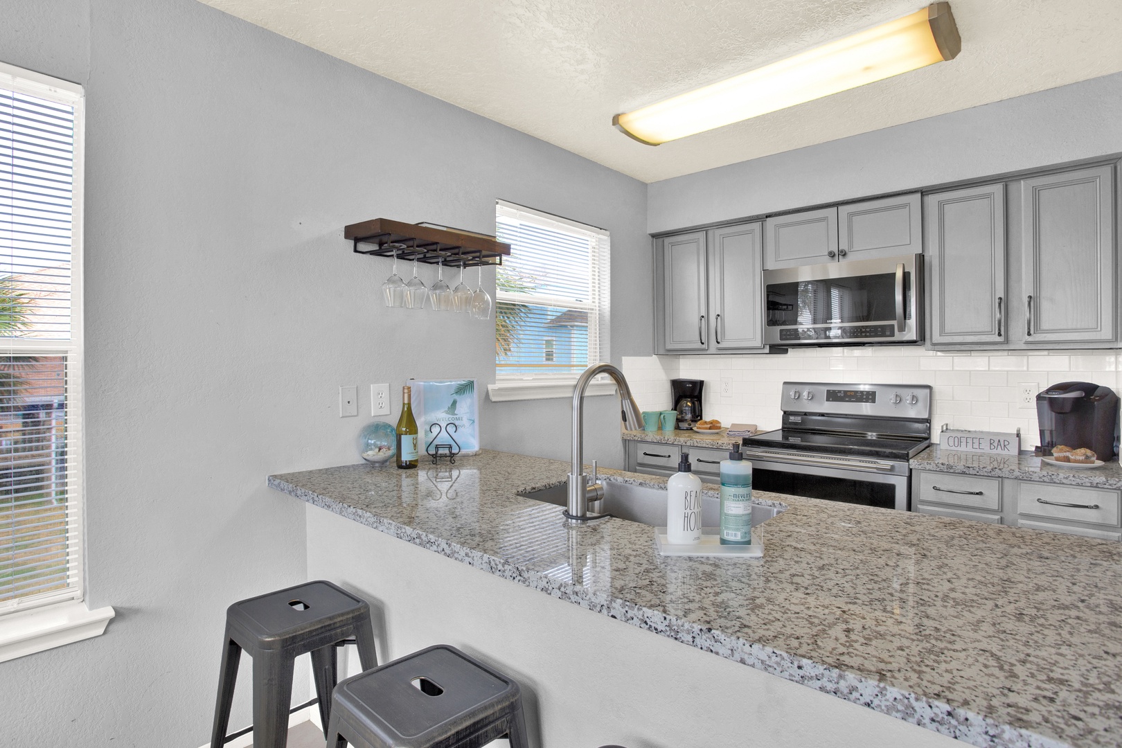 Your fully equipped kitchen features granite countertops, modern appliances, and a welcoming breakfast bar—perfect for brewing morning coffee or preparing meals together during your stay.