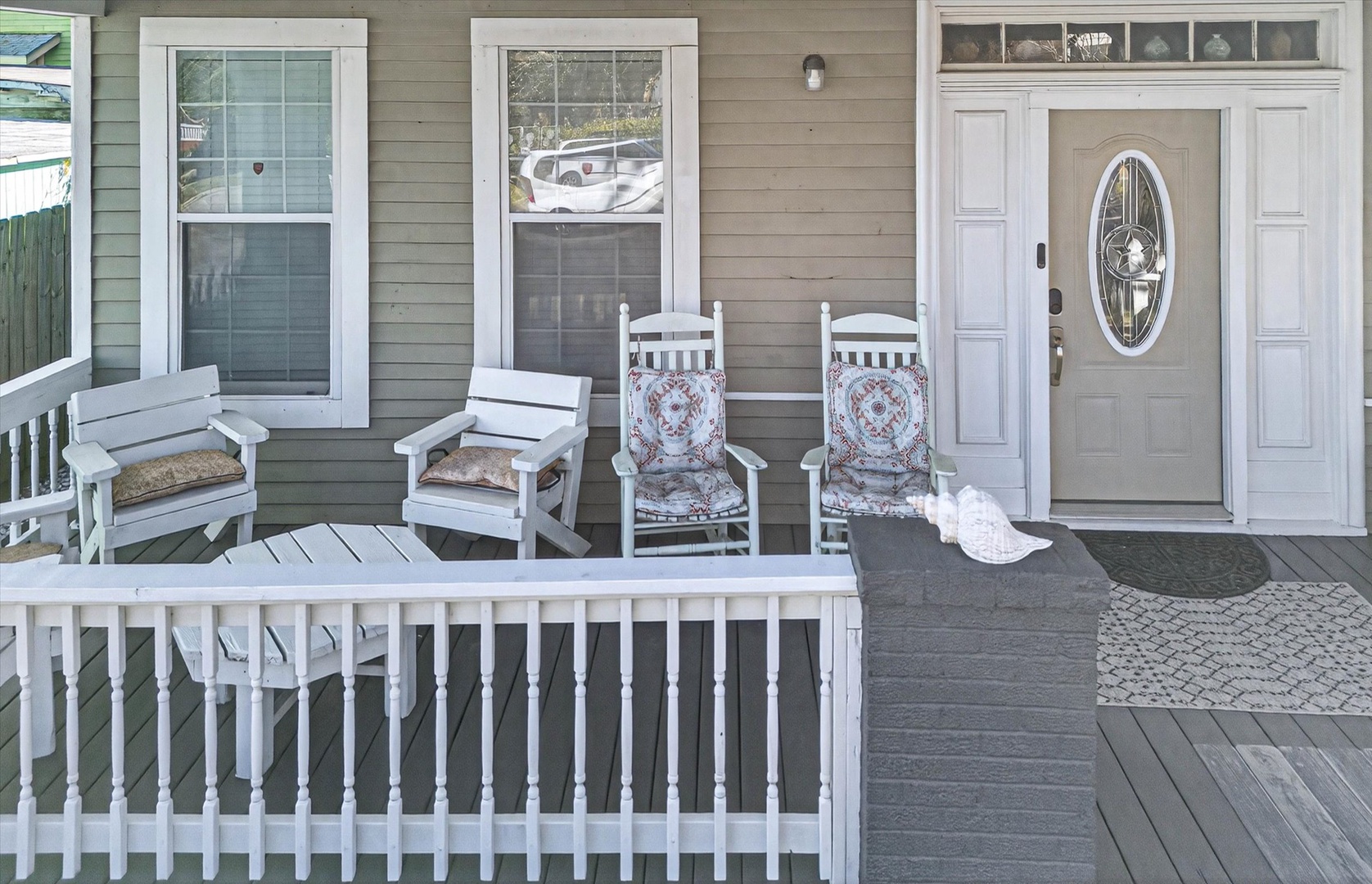 Charming front porch welcomes you with rocking chairs and coastal-inspired seating—perfect for your morning coffee and evening relaxation.