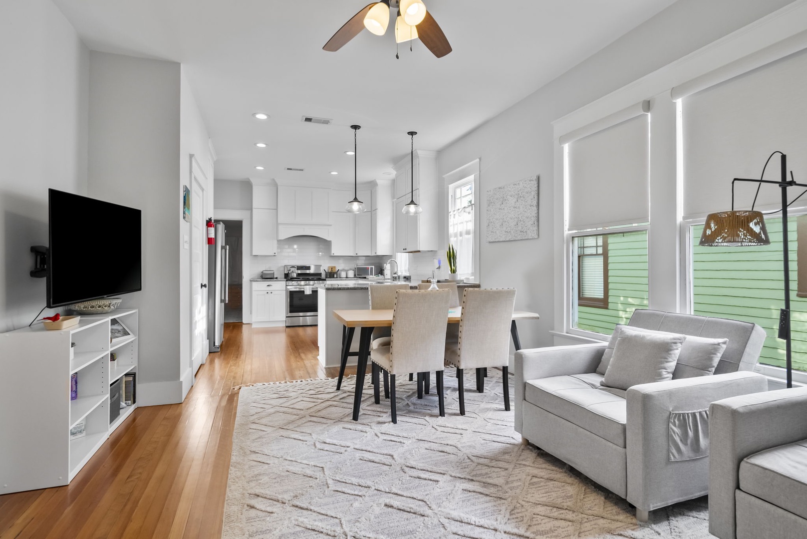 Bright open living space with seating and hardwood floors.