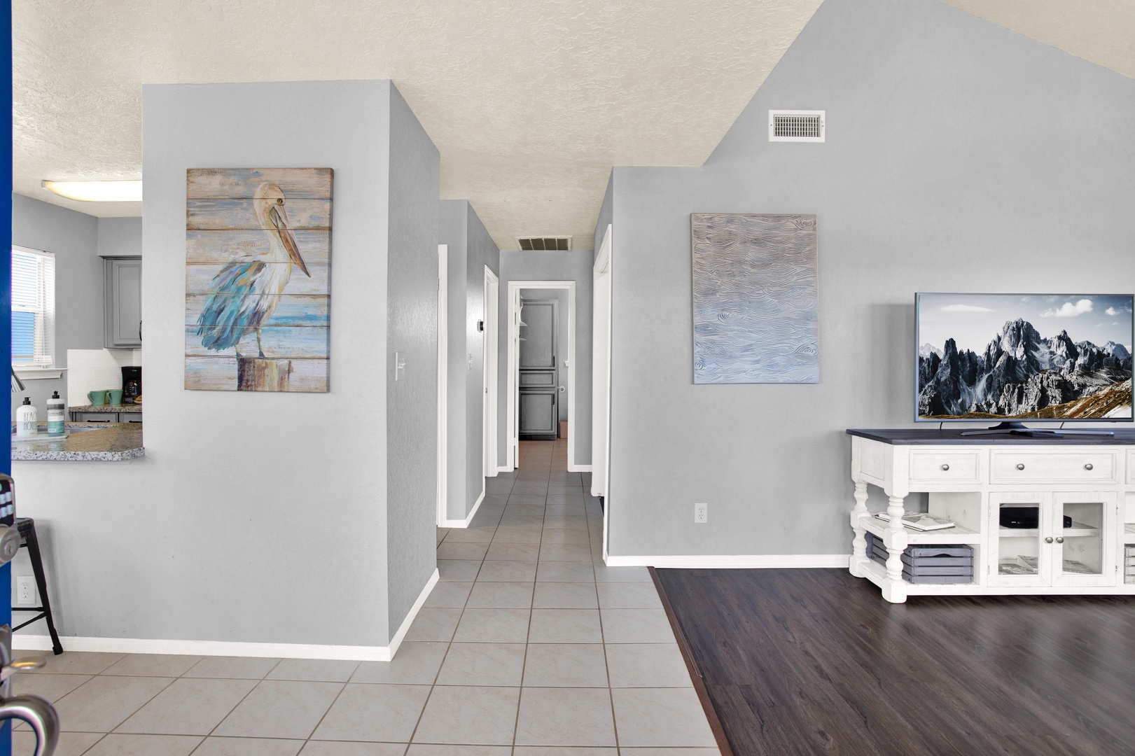 Bedrooms are down the hall, through the open space with coastal artwork and modern touches that make you feel instantly at ease.