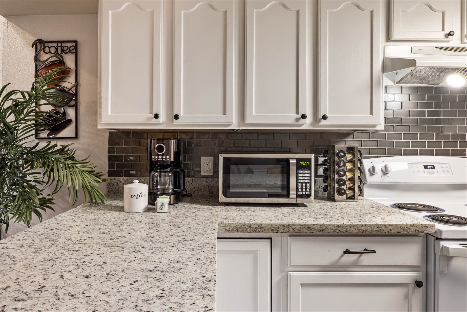 Granite kitchen with modern appliances and coffee.